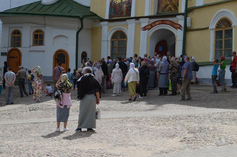 Толпа, собравшаяся у входа в пещеры. Обратите внимание, что многие мужчины и женщины обмотали ноги тканью