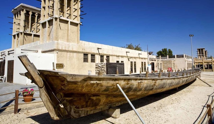 Традиционная арабская лодка на фоне традиционной башни-багдира